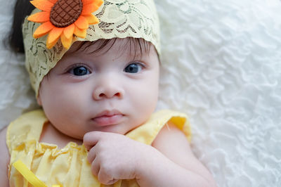 Close-up portrait of cute baby girl lying down