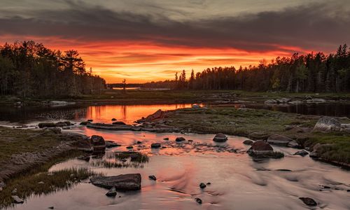 Scenic view of lake against orange sky