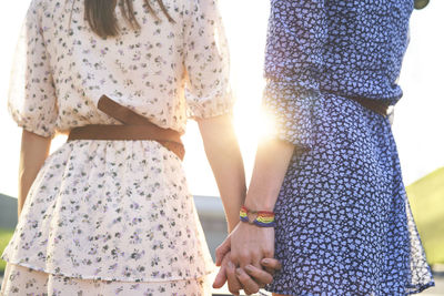 Midsection of couple standing in sunlight