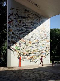 Man with graffiti on wall in city