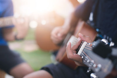 Midsection of man playing guitar