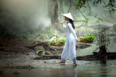 Woman with umbrella standing on wet land during rainy season