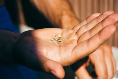 Close-up of hand holding dry material