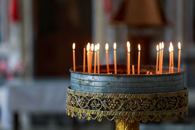 Close-up of candles burning in church