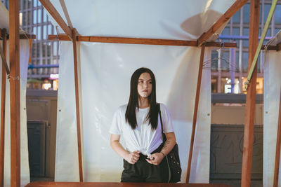 Young woman standing against plastic