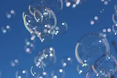 Close-up of bubbles against blue sky