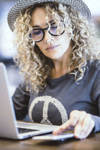 Portrait of young woman using laptop at table