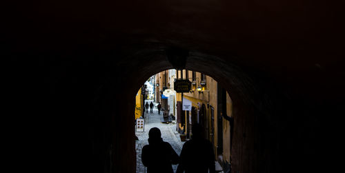 People walking in illuminated tunnel