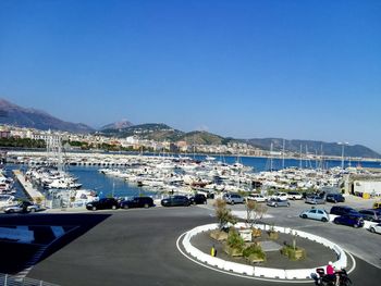 Boats moored on river by mountains against clear sky