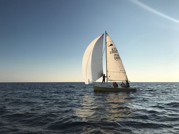 Sailboat sailing on sea against clear sky