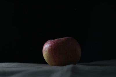 Close-up of apple on table against black background