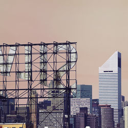 Huge billboard and buildings against clear sky during sunset