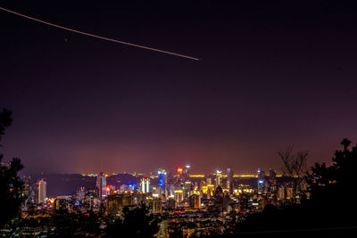 Illuminated cityscape against sky at night