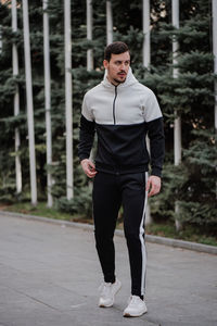 Full length portrait of young man standing in city