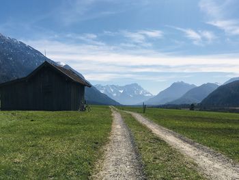 Road amidst field against sky