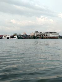 Scenic view of sea by buildings against sky