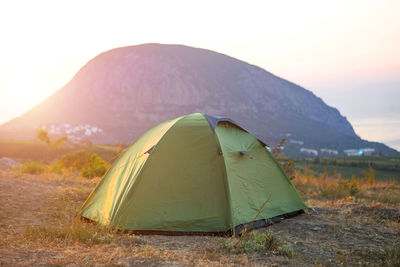 Installed tourist tent in the mountains with a view of the sea and sunrise. domestic 