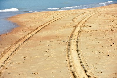 High angle view of tire tracks on beach
