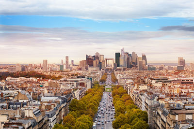 High angle view of city buildings against cloudy sky