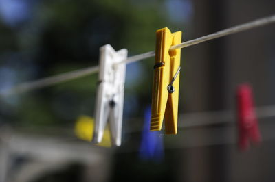 Close-up of clothespin hanging on clothesline outdoors