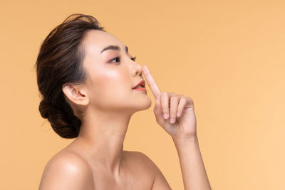 Portrait of young woman against gray background