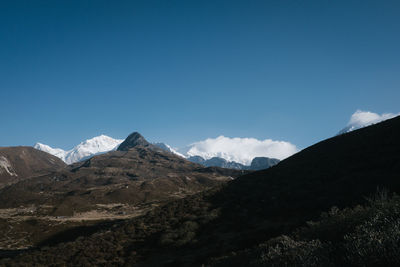 Scenic view of mountains against blue sky