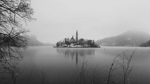 Scenic view of lake by buildings against sky