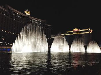 Low angle view of illuminated fountain against sky at night