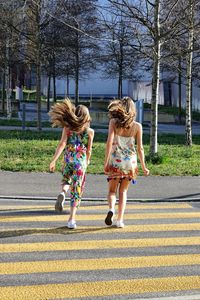 Rear view of women walking on road