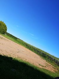 Scenic view of land against blue sky