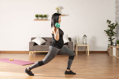 Pregnant woman exercising with dumbbells at home