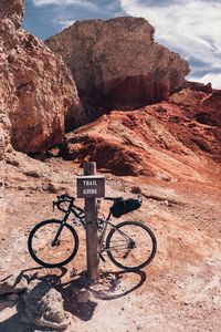 Bicycle parked on land against sky