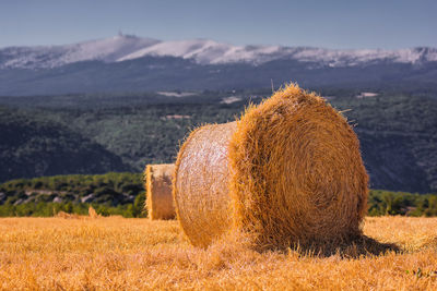 Hay bales on field against sky