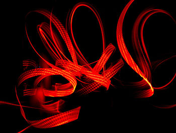 Close-up of illuminated red lights against black background