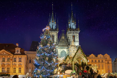 Decorated christmas tree outside tyn church at night