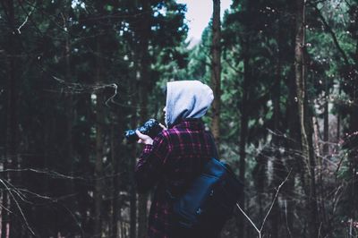 Rear view of woman walking in forest