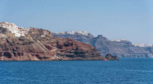 Scenic view of sea and mountain against clear sky