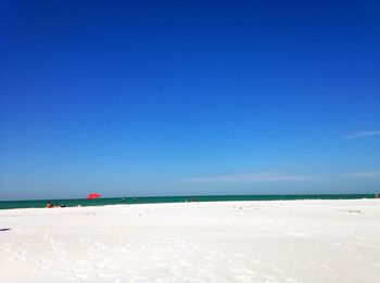 Scenic shot of calm beach against blue sky