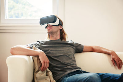 Midsection of man sitting on sofa at home