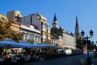 Buildings in city against clear blue sky
