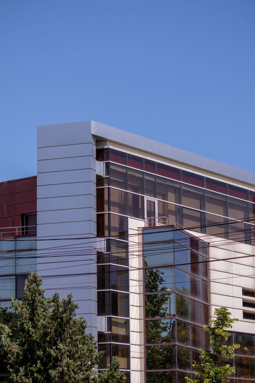 LOW ANGLE VIEW OF MODERN BUILDINGS AGAINST CLEAR BLUE SKY