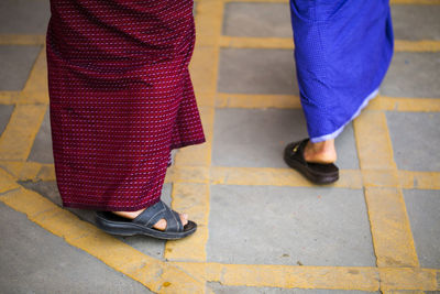 Low section of two men walking on footpath