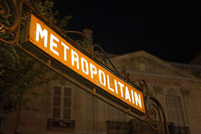 Low angle view of illuminated information sign at night