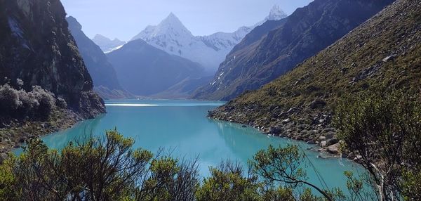 Scenic view of lake by mountains against sky