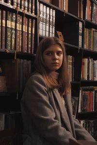 Portrait of young woman standing in library