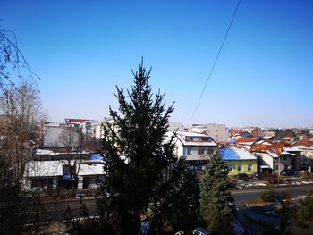 Buildings in town against clear blue sky