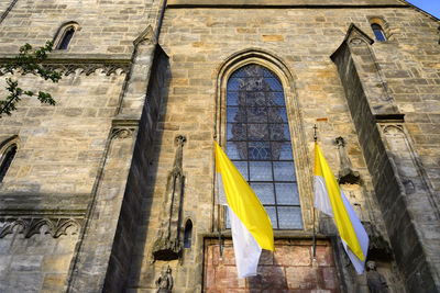 Low angle view of yellow flag on building