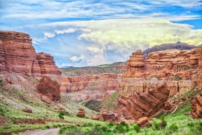 Scenic view of rocky mountains against cloudy sky