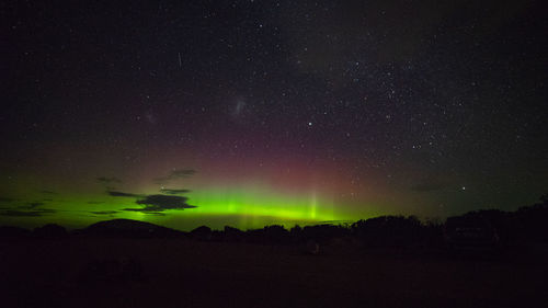 Silhouette landscape against star field at night