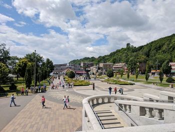 People at town square against cloudy sky